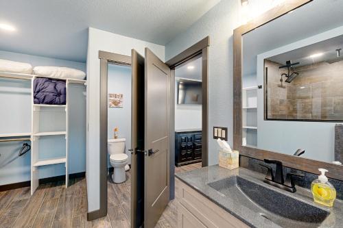 a bathroom with a sink and a toilet and bunk beds at Ruddy's Cabins in Sturgis