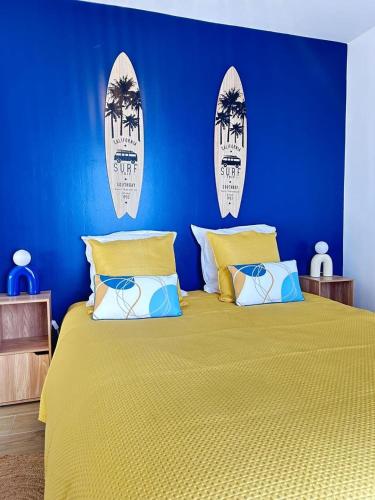une chambre bleue avec un lit et des planches de surf au mur dans l'établissement Appartement spacieux de standing CALAIS PLAGE, à Calais