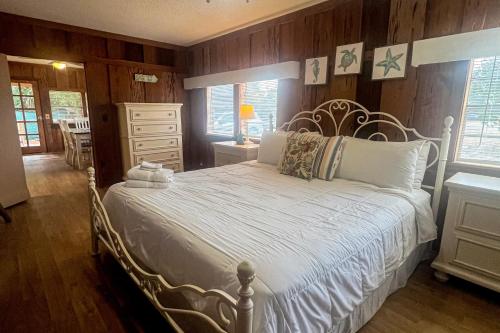 a bedroom with a white bed with wooden walls at Sealevel in St. George Island