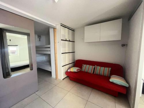 - un canapé rouge avec des oreillers dans une petite chambre dans l'établissement Résidence Arc En Ciel B - T2 cosy à proximité du départ des pistes, vue sur la montagne MAE-0551, à Vénosc