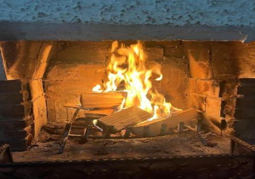 a fire in a brick oven with a bench in it at Appartamento 135mq - Splendida Vista Sul Lagorai in Cavalese