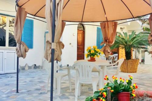 a table and chairs under an umbrella on a patio at Casa Filomena in Ischia