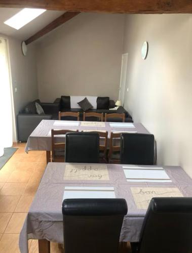 une pièce avec des tables, des chaises et un canapé dans l'établissement Meadow Brook Gites, à La Lande-de-Goult