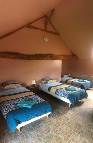 Cette chambre mansardée comprend 3 lits. dans l'établissement Meadow Brook Gites, à La Lande-de-Goult