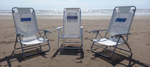 two folding chairs sitting on the beach at La Casita del Mar in Mar del Tuyú