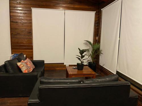 a living room with two black couches and a table at El Parador in Paso de la Patria