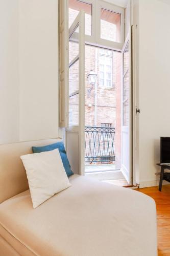 un lit blanc dans une chambre avec une fenêtre dans l'établissement Beau T2 au centre historique, à Toulouse