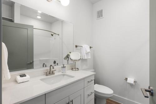 a white bathroom with a sink and a toilet at Central Escape Gym, Coffee Bar, Perfect Location in Pflugerville