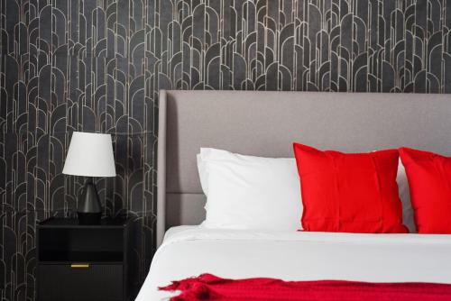 a bedroom with a bed with red pillows and a wallpaper at Central Escape Gym, Coffee Bar, Perfect Location in Pflugerville