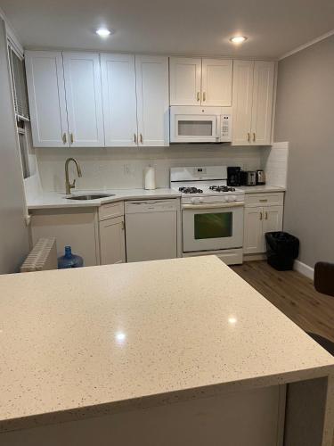 a kitchen with white cabinets and a counter top at Cozy Apartments Woodside near Manhattan in Queens