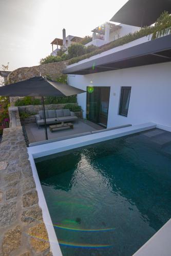 a house with a swimming pool in front of a house at Noima Boutique Hotel Mykonos in Agios Ioannis Mykonos