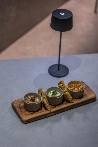 a tray with three bowls of food on a table at Noima Boutique Hotel Mykonos in Agios Ioannis Mykonos
