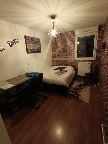 Cette chambre comprend un lit et un bureau. dans l'établissement Chambre dans appartement Saint Martin d'Hères près du Campus, UGA et Neyrpic, à Rhut
