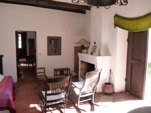 ein Wohnzimmer mit Schaukelstühlen und einem Kamin in der Unterkunft Estancia Las Tacanas in Tafí del Valle