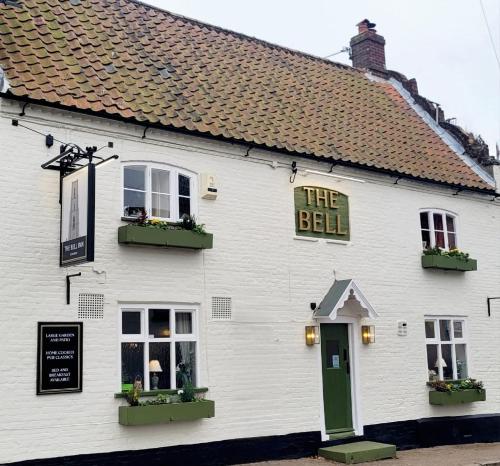 a white building with a sign that reads the bell at The Bell Inn in Norwich