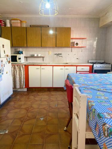 a kitchen with white cabinets and a bed in it at Casa en Mar del Plata - Colinas de Peralta Ramos in Mar del Plata