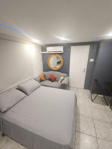a bedroom with a large white bed and a mirror at A1 Apartments Aruba in Oranjestad