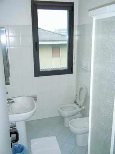 a bathroom with a toilet and a sink and a window at Residence Vezzoli in Boario Terme