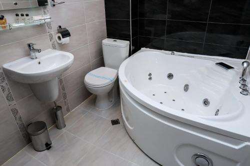 a bathroom with a sink and a tub and a toilet at Hotel Bulgaria in Kŭrdzhali