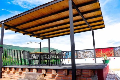 a wooden pergola with a table and chairs on a deck at Casa Aida in San Pablo Villa de Mitla