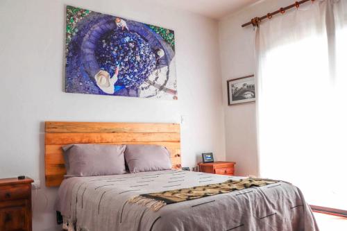 a bedroom with a bed and a painting on the wall at Casa Aida in San Pablo Villa de Mitla