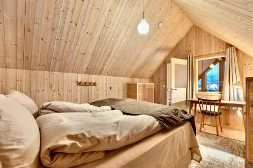 two beds in a room with a wooden ceiling at Cathedral Lodge in Tromsø
