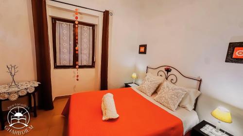 a bedroom with an orange bed and a window at Apartamentos Gharb Diem in Tavira