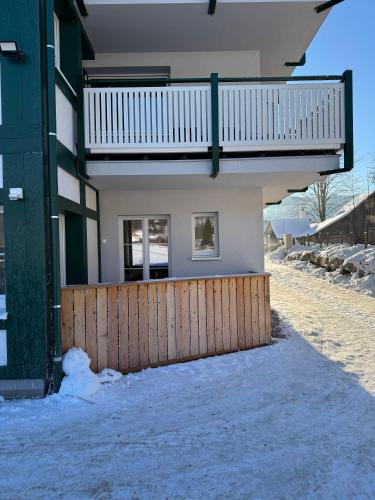 a house with a wooden fence in the snow at Loetje in Gosau