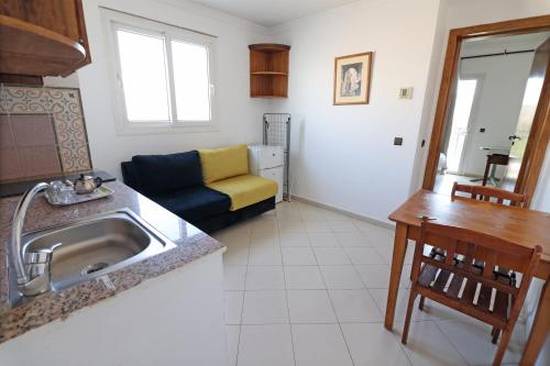 a kitchen with a sink and a living room with a couch at Flathotel agadir in Agadir