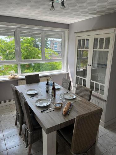 d'une salle à manger avec une table, des chaises et des fenêtres. dans l'établissement Opale Pearls, à Boulogne-sur-Mer