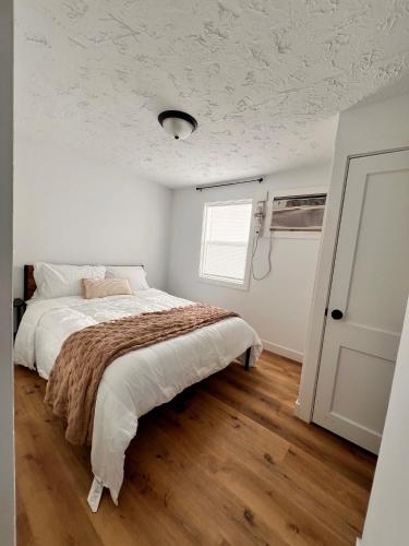 a white bedroom with a bed and a window at Quaint Lakeview Getaway Trails & Town at Your Doorstep in Walker