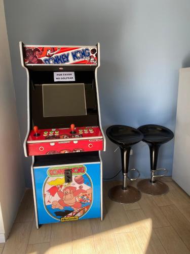 a video game machine and two stools in a room at Casa de campo in De Cauquenes