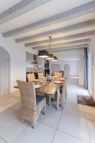 une salle à manger avec une table et des chaises en bois dans l'établissement TY CARN - Belle maison bretonne à 100m de la mer, à Ploudalmézeau