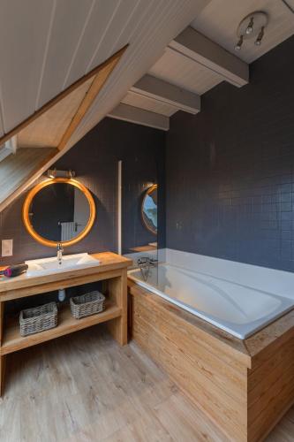 une grande salle de bain avec une baignoire et un lavabo dans l'établissement TY CARN - Belle maison bretonne à 100m de la mer, à Ploudalmézeau