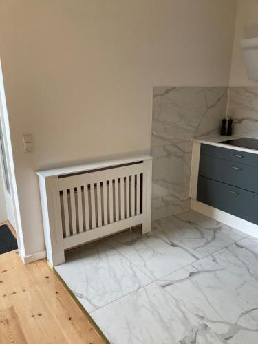 a kitchen with a white counter and marble floor at Moderne og centralt rækkehus i Herning in Herning