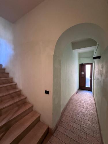 an empty hallway with stairs and a door at Aselli Palace in Cremona