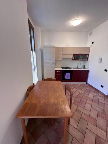 a kitchen with a wooden table in a room at Aselli Palace in Cremona