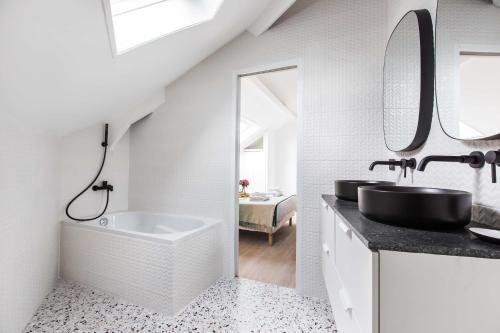 La salle de bains blanche est pourvue d'un lavabo et d'une baignoire. dans l'établissement Comfortable studio - 2P - Sentier, à Paris