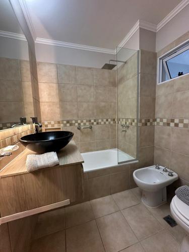 a bathroom with a sink and a tub and a toilet at Departamento Junín 4 Bitcoins House in Corrientes