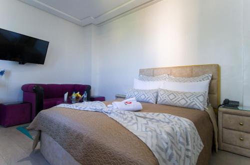 a bedroom with a large bed and a tv at Mamora Bay in Tangier