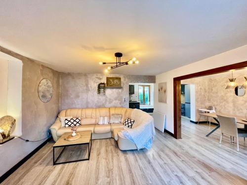 un salon avec un canapé et une table dans l'établissement Maison 4-6 personnes proche Gerardmer, à Aumontzey