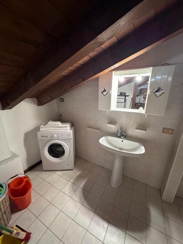 a bathroom with a sink and a washing machine at Dante 13 Flat in Cremona