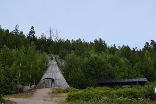 a building with a roof in the middle of a forest at Serena Villas in Espoo