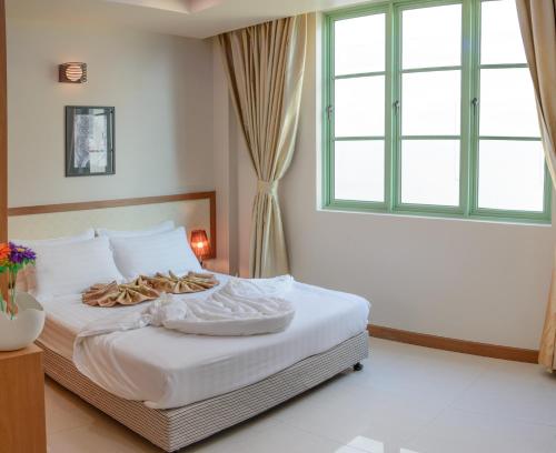 a bedroom with a bed with white sheets and a window at Season Holidays at Hulhumale with Transfer in Hulhumale