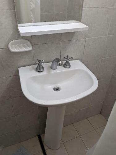 a white sink in a bathroom with a mirror at Apartamento Paracao in Paraná