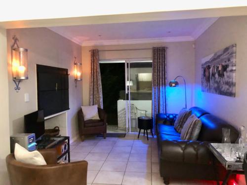 a living room with a blue couch and chairs at #SilverSands Coastal Retreat in Betty's Bay in Bettyʼs Bay