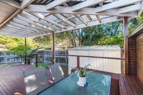 a patio with a table and chairs on a deck at StayAU 4BRM Charming Modern Home in Mt Colah in Mount Colah