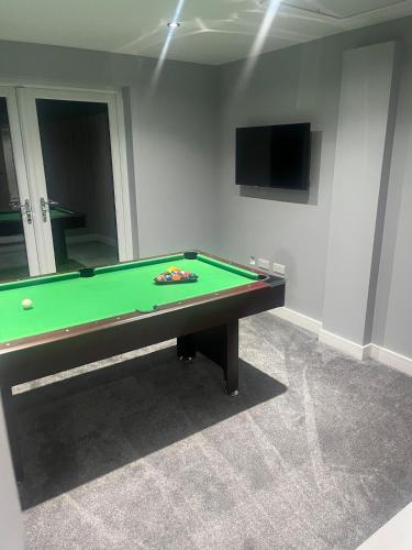 a green pool table in a room with a tv at Galway Glamour in Bircotes