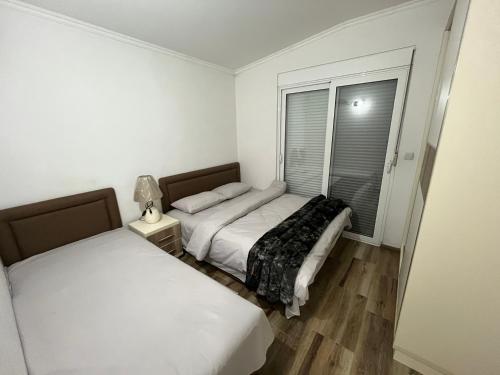 two beds in a small room with a window at Apartments Visar in Ulcinj