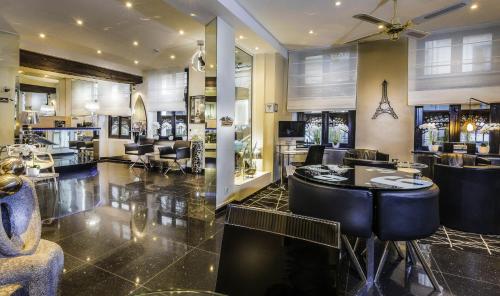 un salon avec des chaises noires et un salon de coiffure dans l'établissement Hotel Ile de France Opéra, à Paris